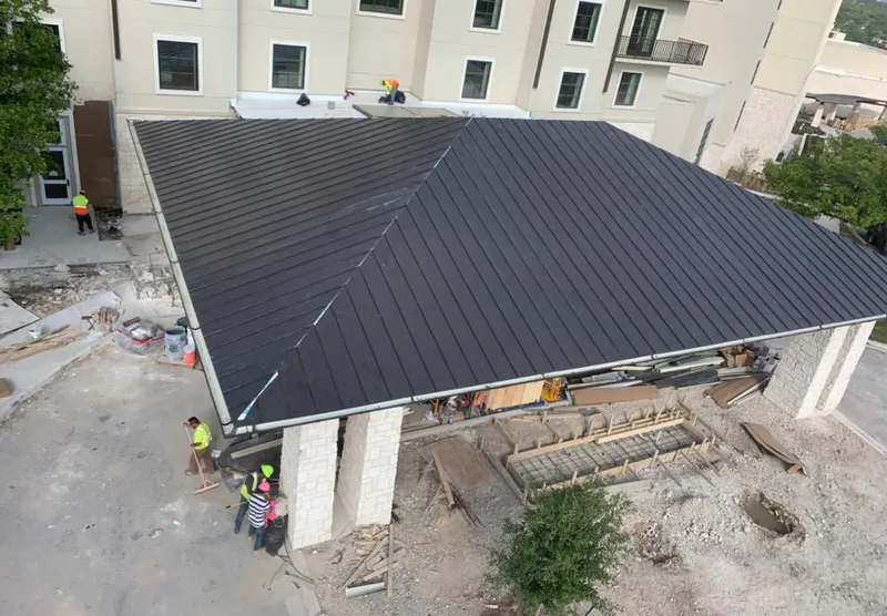 Metal roofing installation team working on a commercial building in Dryden